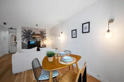a dining room and living room with a table and chairs at Les Palmiers, quiet and air-conditioned in Nice