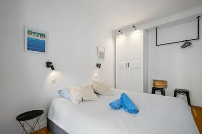 a bedroom with a bed with two blue pillows on it at Les Palmiers, quiet and air-conditioned in Nice