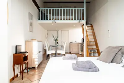 a bedroom with a bed and a desk and a kitchen at Le Riviera France in Nice