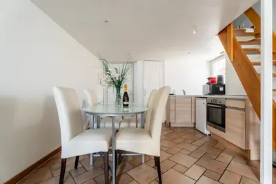 a dining room with a glass table and white chairs at Le Riviera France in Nice