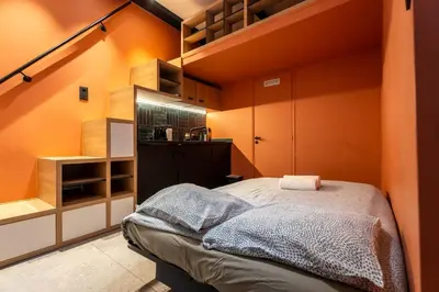 a small bedroom with orange walls and a bed at La Casa Nissa in Nice