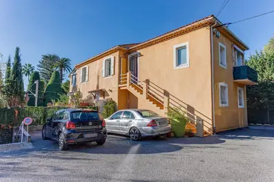 two cars parked in a parking lot in front of a house at STUDIO AZUR AP4487 By Riviera Holiday Homes in Villefranche-sur-Mer