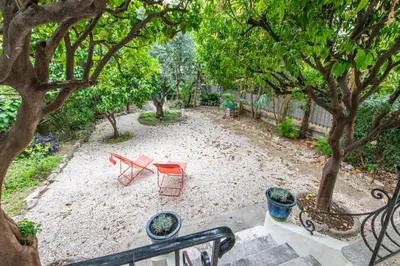 a backyard with a table and chairs and trees at Happyfew maison Michelet in Nice