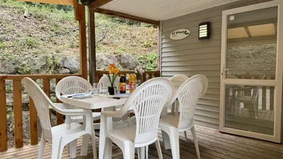 a white dining table and chairs on a deck at Cosy mobil-home wifi clim in Cagnes-sur-Mer