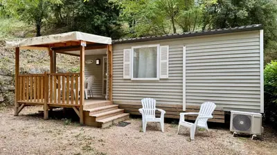 a small cabin with two chairs and a porch at Cosy mobil-home wifi clim in Cagnes-sur-Mer