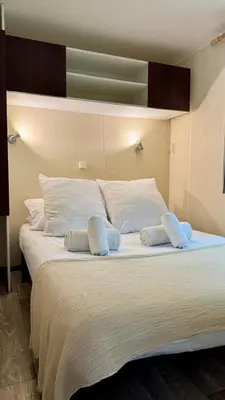 a large white bed with two pillows on it at Cosy mobil-home wifi clim in Cagnes-sur-Mer