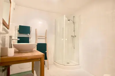 a white bathroom with a shower and a sink at Charmant appartement au sein de la vieille ville in Villefranche-sur-Mer
