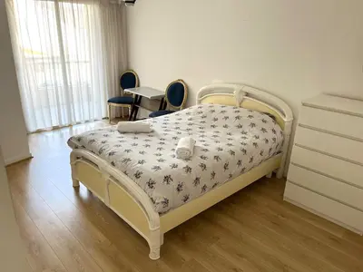 a bedroom with a bed and two chairs and a dresser at Charming 2-room near beach with terrace in Cagnes-sur-Mer