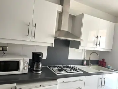a kitchen with white appliances and a table in it at Charming 2-room near beach with terrace in Cagnes-sur-Mer