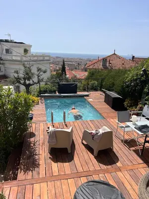 a swimming pool on top of a wooden deck at Villa Arty Nice - Vue Mer Panoramique, Piscine & Design in Nice
