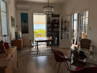 a living room with a dining room table and chairs at Villa Arty Nice - Vue Mer Panoramique, Piscine & Design in Nice