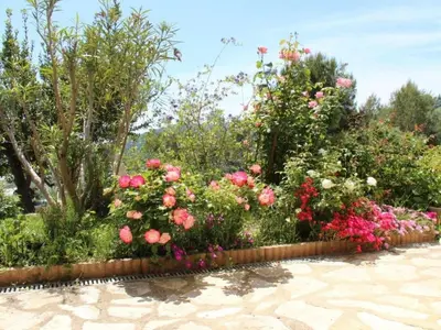 a garden of roses and other flowers at Holiday Home Rocabel mit Blick auf das Wasser by Interhome in Gattières