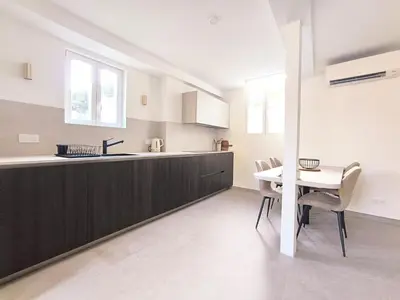 a kitchen and dining room with a table and chairs at Elegant Renovated Apartment Nice Port AC Sleeps 4 in Nice