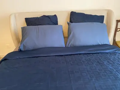 a bed with blue sheets and pillows at Cosy Nice Promenade des Anglais Beach Apartment 2 rooms in Nice