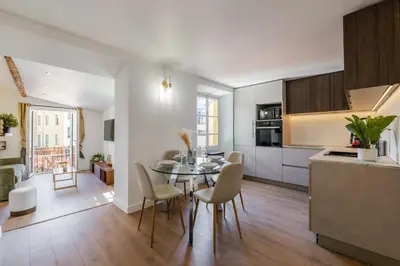 a kitchen and living room with a table and chairs at Bright 3 rooms apartment close to Place Massena in Nice