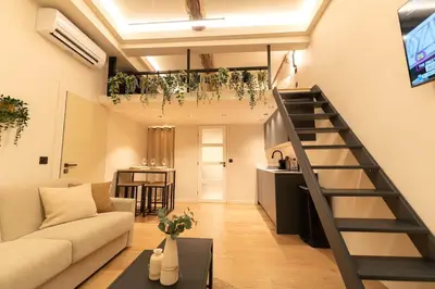 a living room with a couch and a staircase at Charmant Duplex Vieux Nice, proche mer, WiFi, Clim in Nice