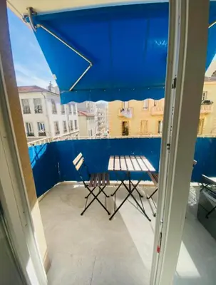 a blue umbrella and a chair on a balcony at Magnifique studio avenue des diables bleus in La Celle-sous-Gouzon