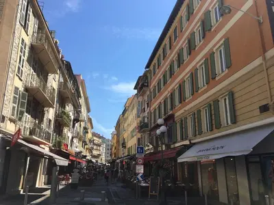 a city street with buildings and people walking down the street at Studio cosy proche des plages & promenade in Nice