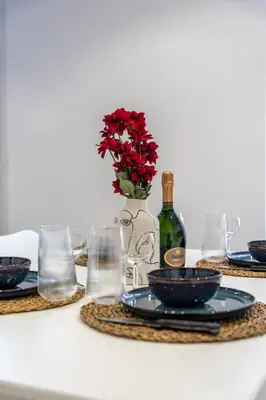 a table with plates and a bottle of wine and flowers at Bright apartment in Nice in Nice