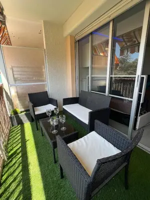 a balcony with two chairs and a table with wine glasses at Sea view appartment in Nice