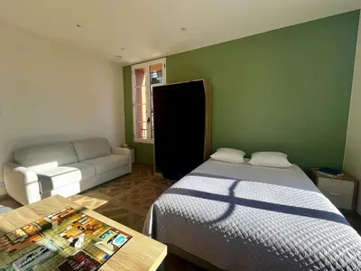 a bedroom with a bed and a couch and a table at Studio Olivier avec terrasse à Cagnes-sur-Mer in Cagnes-sur-Mer