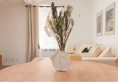 a white living room with a table with a vase at Magnifique Confortable & Rénové au Port de Nice in Nice