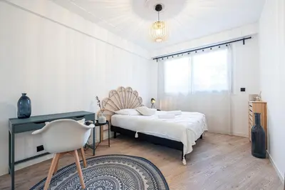 a bedroom with a bed and a chair in it at Grand T4 chic près du Port Balcon & Clim in Nice