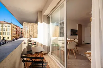 a small apartment with a balcony with a table and chairs at Grand T4 chic près du Port Balcon & Clim in Nice