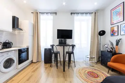 a kitchen and living room with a table and chairs at Studio Cosy et confortable hyper centre in Nice