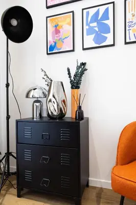 a black dresser in a living room with a chair at Studio Cosy et confortable hyper centre in Nice