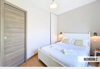 a bedroom with a white bed and a large sliding door at Nestor&Jeeves - GELATO - Bright - Balcony in Nice