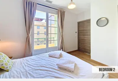 a bedroom with a large white bed with a window at Nestor&Jeeves - GELATO - Bright - Balcony in Nice