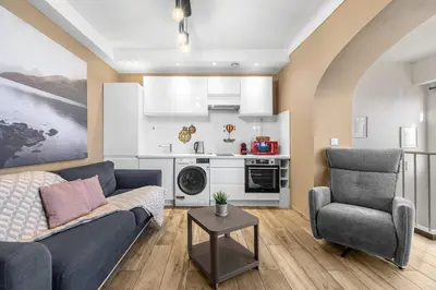 a living room with a couch and a chair at Appartement Charme de la Promenade vue mer - Welkeys in Nice