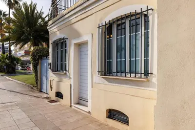 a white building with a door and a window at Appartement Charme de la Promenade vue mer - Welkeys in Nice