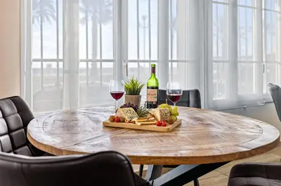 a table with a plate of food and two glasses of wine at Appartement Charme de la Promenade vue mer - Welkeys in Nice