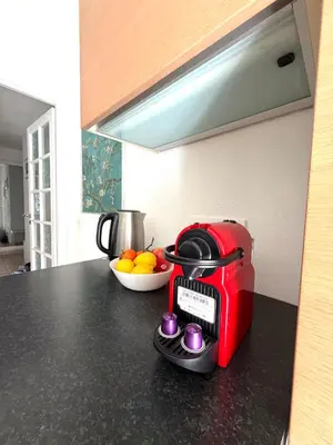 a red toaster on a kitchen counter with a bowl of fruit at Le MIAMI in Nice