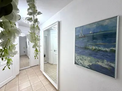 a hallway with a painting on the wall and a mirror at Le MIAMI in Nice