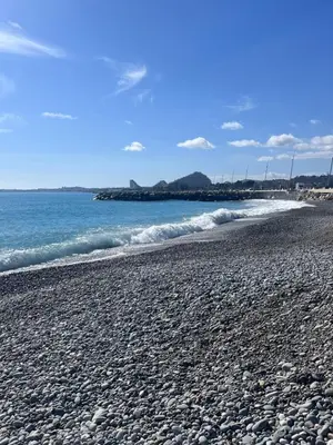 a rocky beach with the ocean in the background at De Gaulle 2 pièces Сentral Appartement in Cagnes-sur-Mer