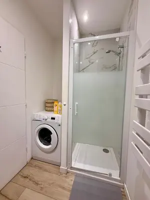 a laundry room with a washing machine and a washer at Charmant studio avec terrasse pour amoureux in Nice