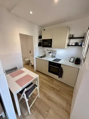 a small kitchen with a table and a small table and a tableablish at Charmant studio avec terrasse pour amoureux in Nice