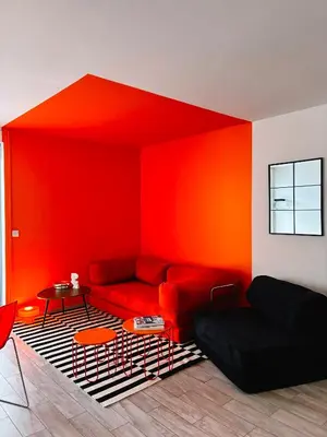 a red living room with a couch and a table at Holidays 80 in Saint-Laurent-du-Var