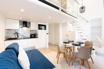 a living room with a blue couch and a table at Duplex moderne climatisé Carré d'or in Nice