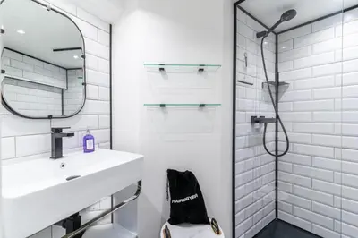 a white bathroom with a sink and a shower at La Perle de Masséna in Nice