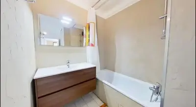 a bathroom with a sink and a tub and a mirror at Nice collines in La Trinité
