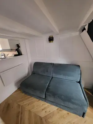 a green couch in a small room in a room at Studio Cosy Mezzanine 2-4p Carré d'Or in Nice