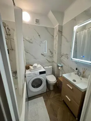 a bathroom with a toilet a sink and a washing machine at Studio Lumiere Nice Center in Nice