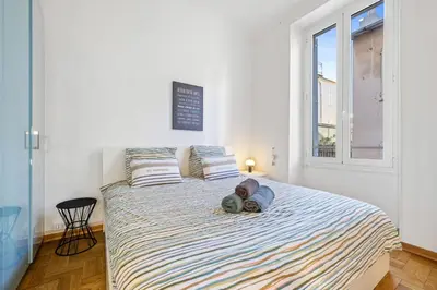 a bedroom with a bed with two hats and a window at Nice Renting - GRIMALDI - Golden Square Best Location Fully Equiped in Nice