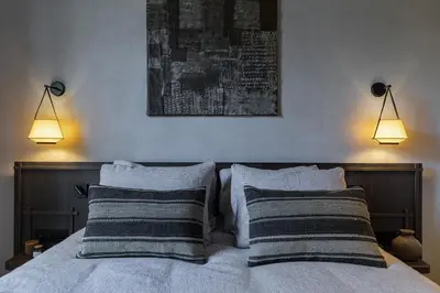 a bedroom with a bed with two pillows and two lights at Wabi-Sabi Hôtel Lorrain in Nice