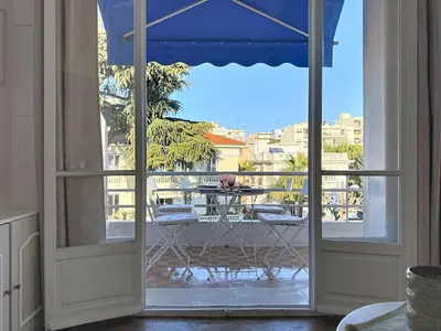 an open door to a balcony with a table and chairs at Large 2 bedroom apartment, Close to Promenade des Anglais in Nice
