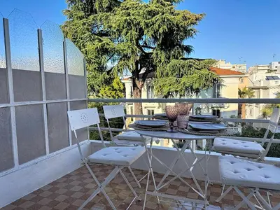 a table and chairs on a balcony with a tree at Large 2 bedroom apartment, Close to Promenade des Anglais in Nice